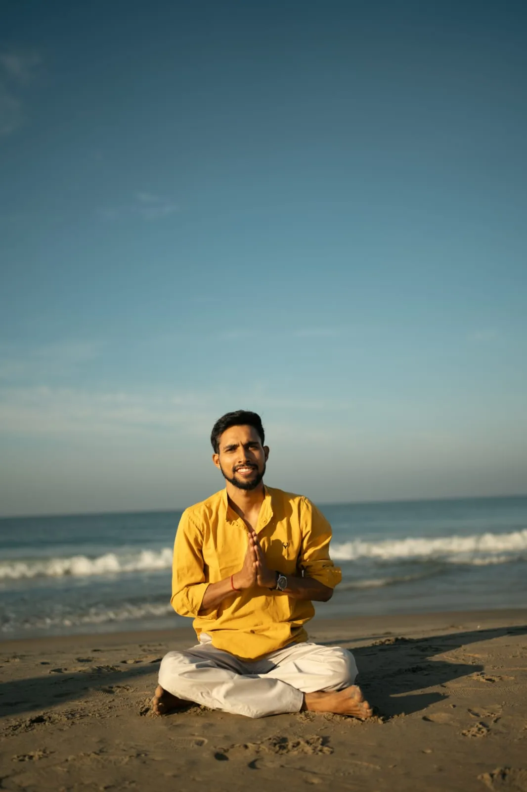 Abhi Nautiyal seated in meditation beside the sea